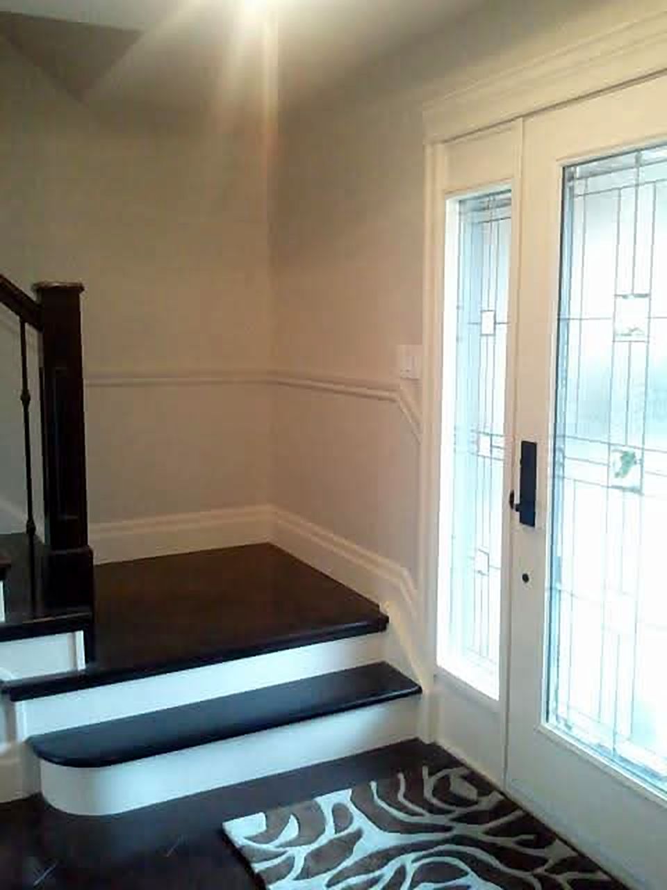 Stair landing beside a front door with glass sidelights
