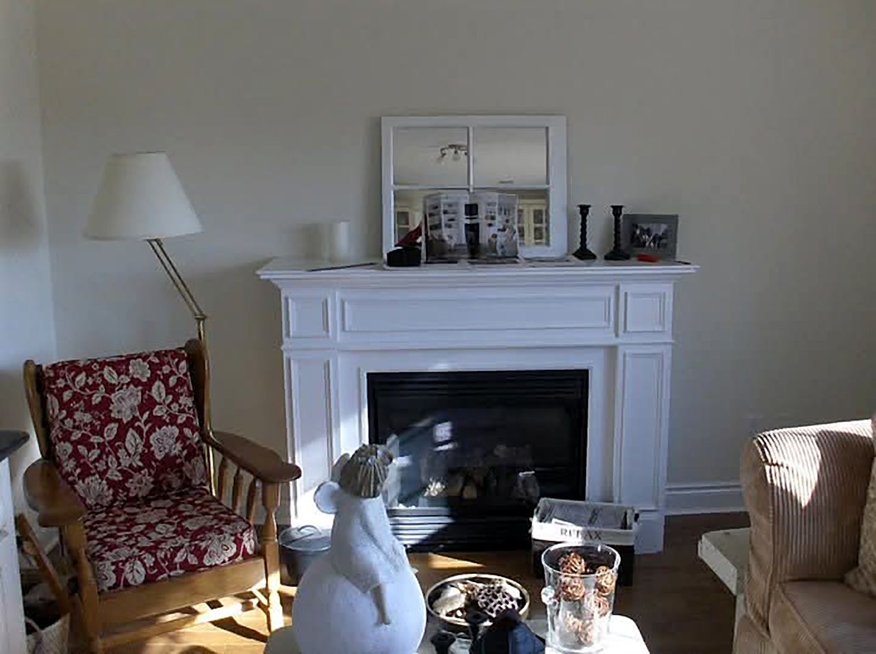 Plain white fireplace mantel on a bare wall