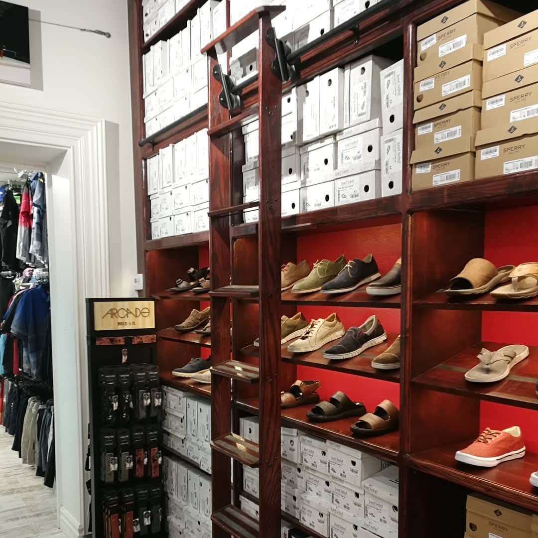 Stained hardwood rolling ladder on a shoe store shelving wall