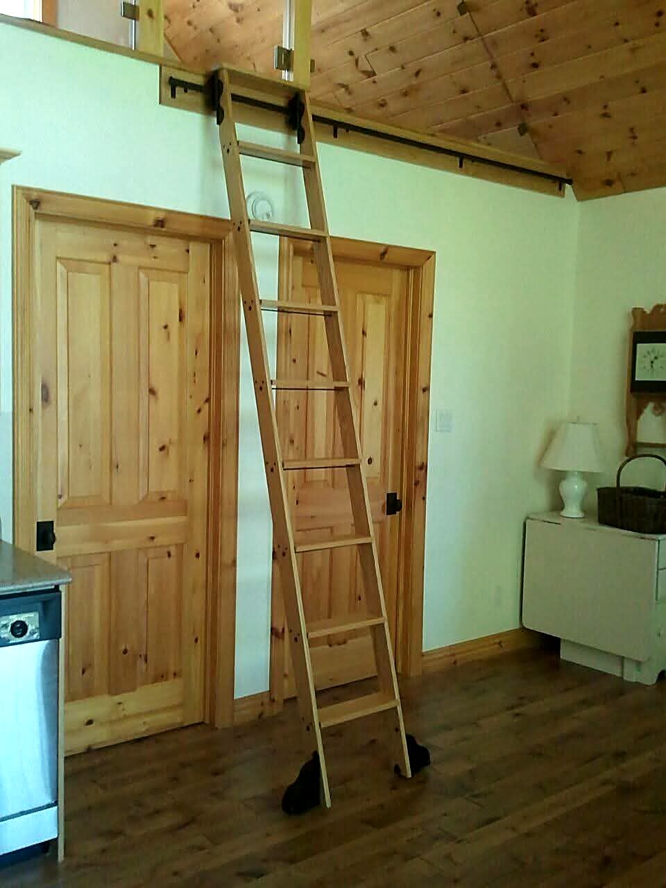 Natural pine rolling ladder up to a loft