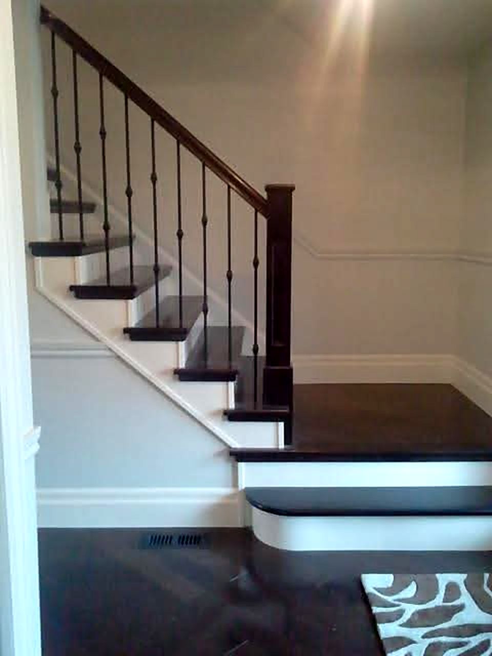 Dark stained stair treads with iron spindles and white risers